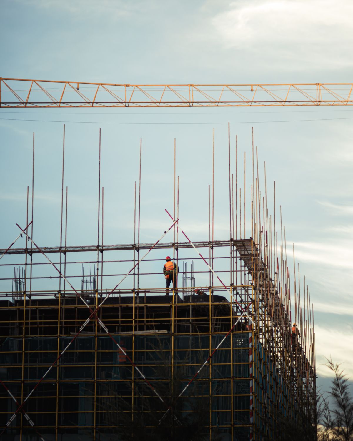 Trabajadores de construcción con equipo de seguridad sobre un andamio metálico